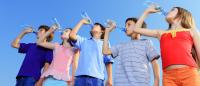 kids in colorful clothes drinking water bottles blue sky hydration