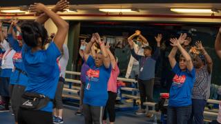 Fitness coach guides participants through group exercises